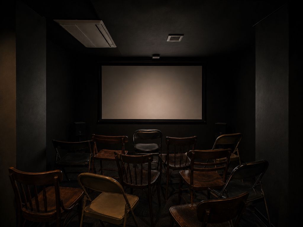 BlackBoxKyoto 会場内観 — スクリーンと椅子が並ぶ暗い上映空間
